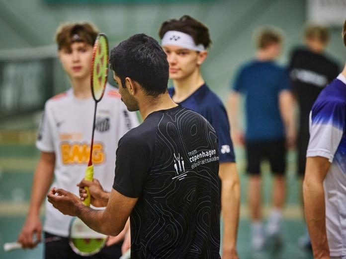 badmintontræner i gang med at instruere spillere