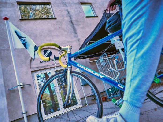 En cykel trækkes forbi Spartas klubhus